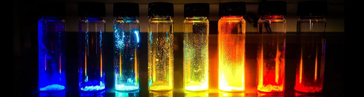 Luminescent LUMORA materials glowing in vials